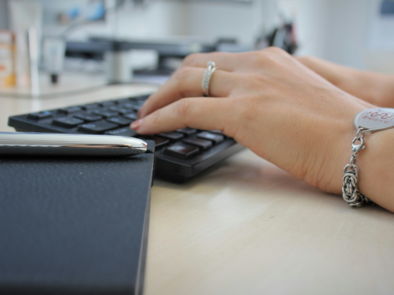 Hands typing on a computer keyboard.